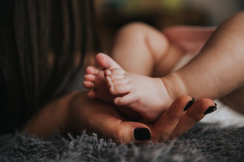 mother's hand holding a baby's foot