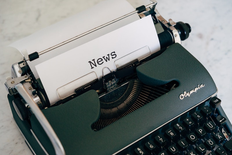 typewriter with piece of paper reading news