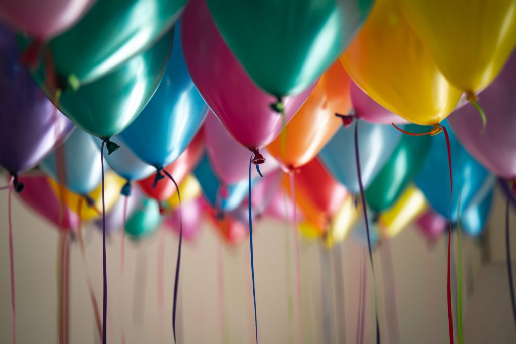 colorful balloons with ribbons hanging